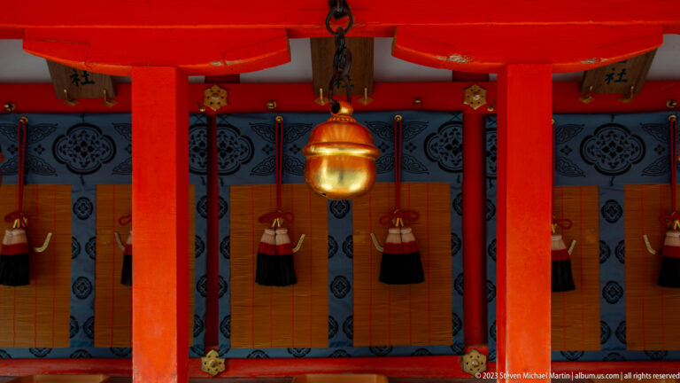 Ceremonial shrine façade with vermilion columns and a hanging lantern.