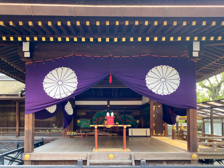Open worship hall with purple curtains displaying white chrysanthemum crests.