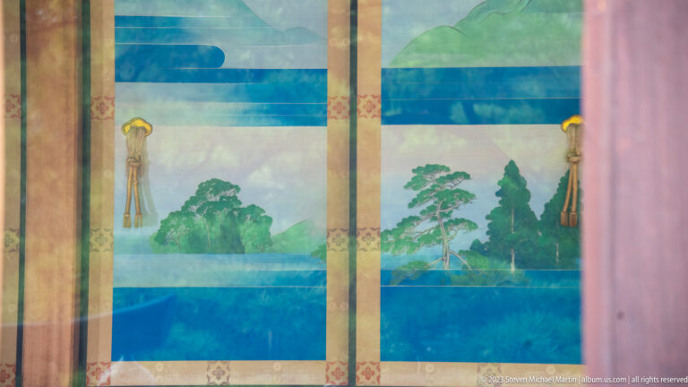 Blue-green landscape with water, trees, and mountains painted across sliding palace panels.