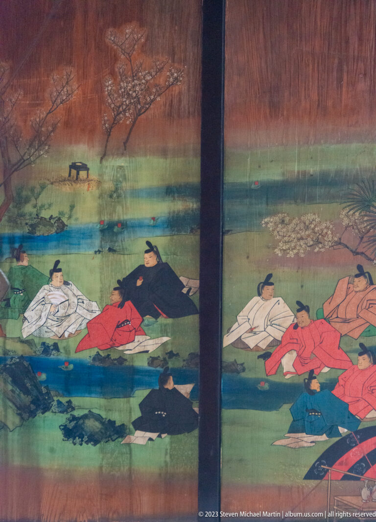 Court figures in formal robes seated in a landscape across painted sliding panels.