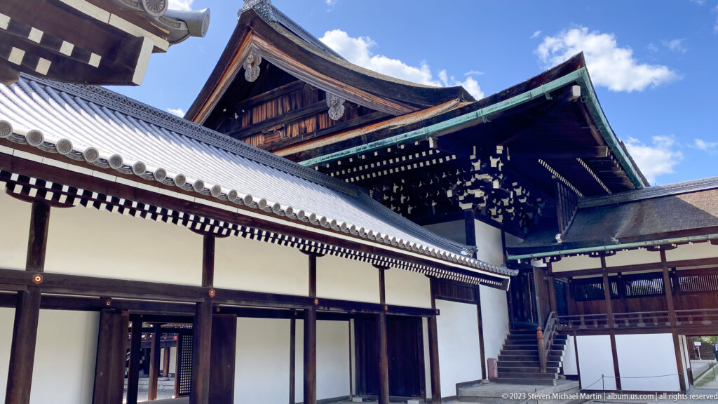 Intersecting palace roofs and gables with gray tiles and dark timber eaves.