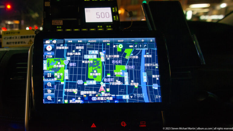 Taxi dashboard navigation screen showing a detailed map of central Kyoto with Japanese labels.