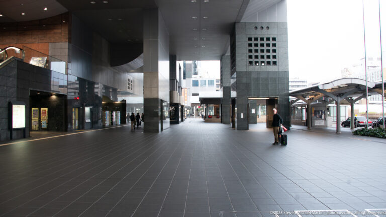 Open exterior forecourt beneath tall structural supports.