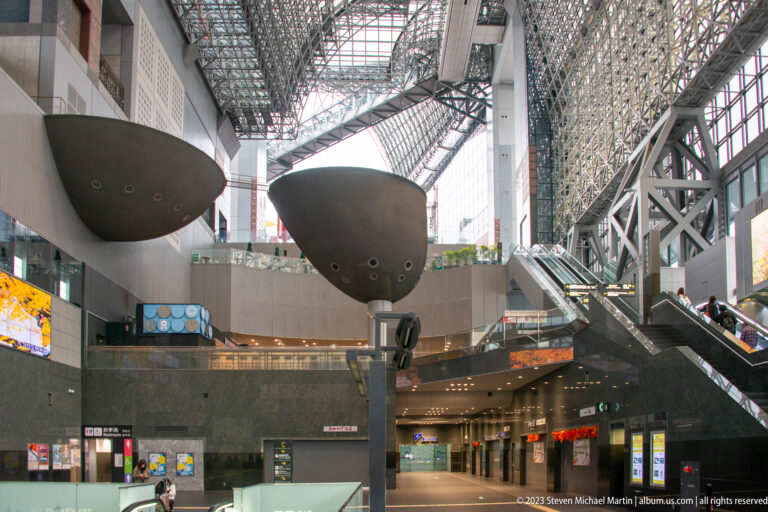 Wide interior view of Kyoto Station atrium beneath the steel-and-glass roof.