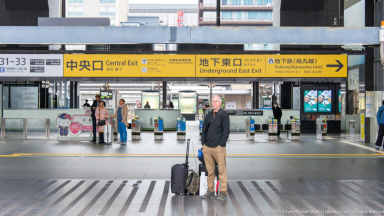 Traveler beneath Central Exit signage at Kyoto Station.