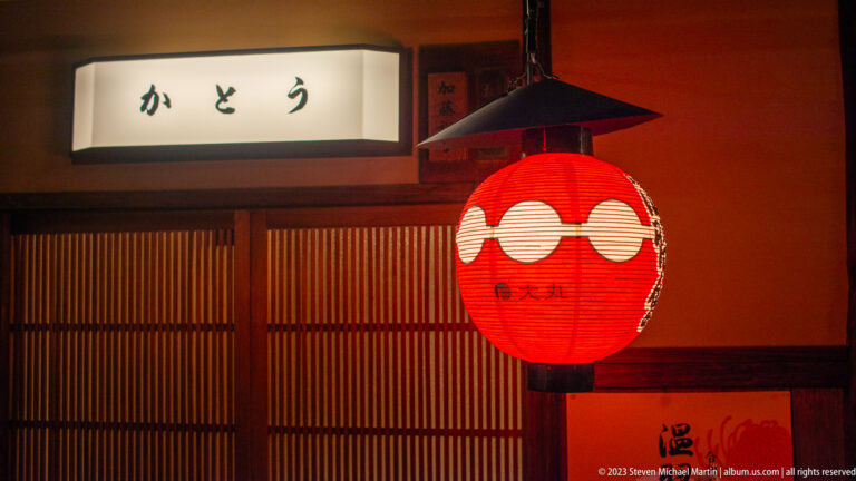Red paper lantern outside traditional restaurant shown at night with the principal architectural, landscape, or street details visible in the composition.