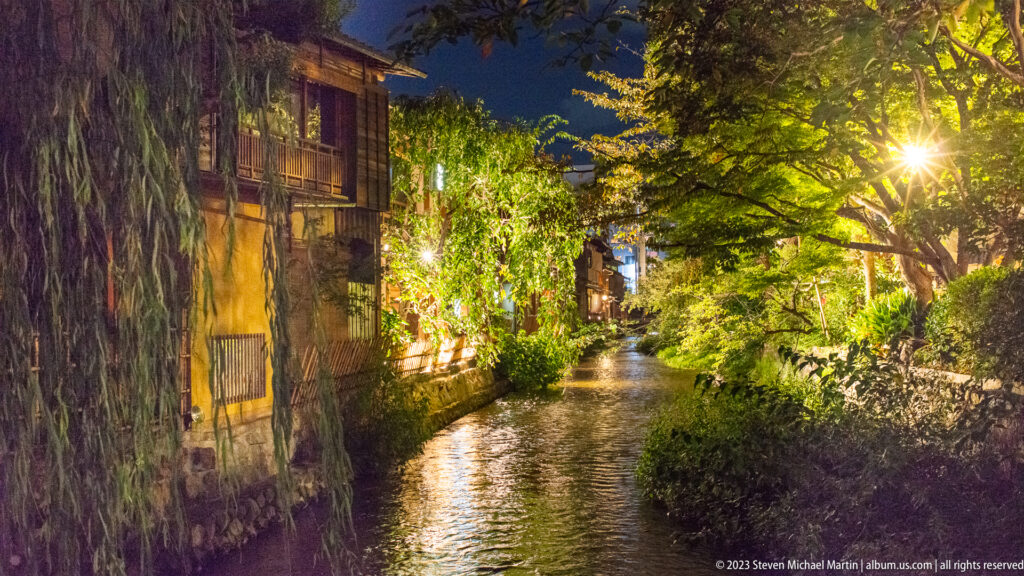 Tree-lined canal at night shown at night with the principal architectural, landscape, or street details visible in the composition.