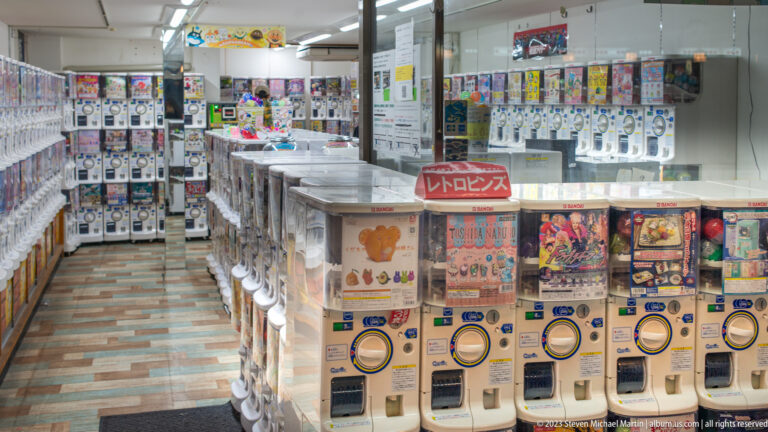 Gashapon capsule machine arcade shown at night with the principal architectural, landscape, or street details visible in the composition.