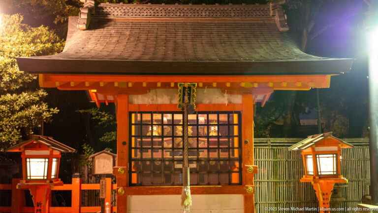 Small illuminated Yasaka Shrine pavilion shown at night with the principal architectural, landscape, or street details visible in the composition.