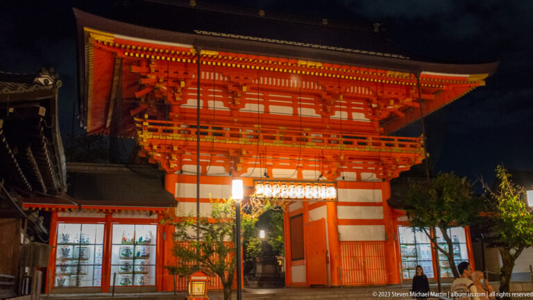 Illuminated gate from oblique angle shown at night with the principal architectural, landscape, or street details visible in the composition.