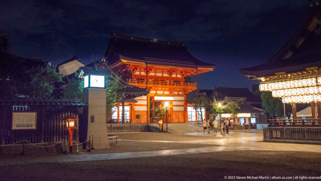 Night view across Yasaka Shrine grounds shown at night with the principal architectural, landscape, or street details visible in the composition.