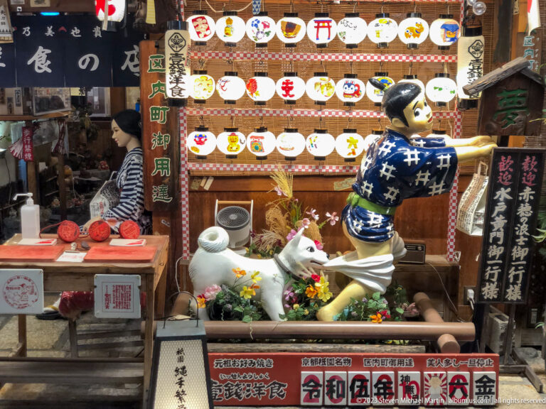 Traditional storefront display with decorative figure shown at night with the principal architectural, landscape, or street details visible in the composition.