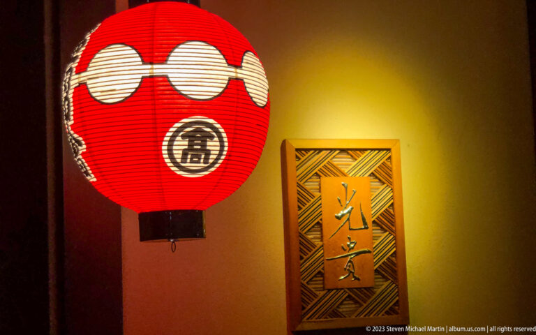 Red paper lantern and entrance plaque shown at night with the principal architectural, landscape, or street details visible in the composition.