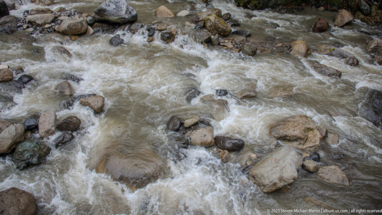 Close overhead view of foaming rapids moving through gray and brown rocks.
