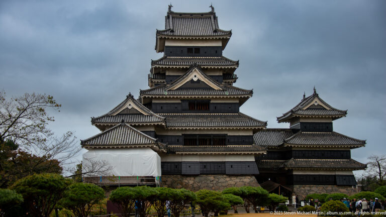 Closer frontal view of Matsumoto Castle’s central keep, attached tower, tiled roofs, and stone foundation.