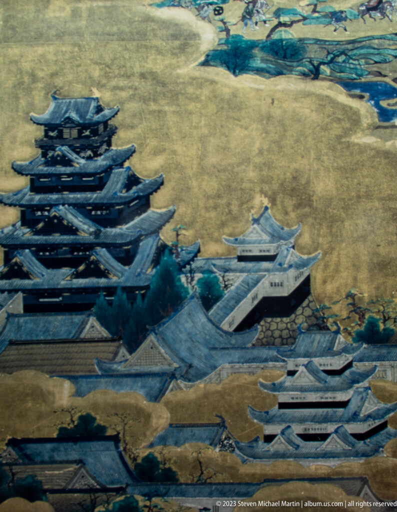 Historical painted panorama of Matsumoto Castle’s dark roofs, white buildings, waterways, and surrounding landscape.