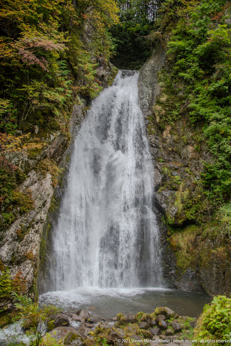 Frontal view of Choshi Falls spreading over a sloped rock face into a pool.