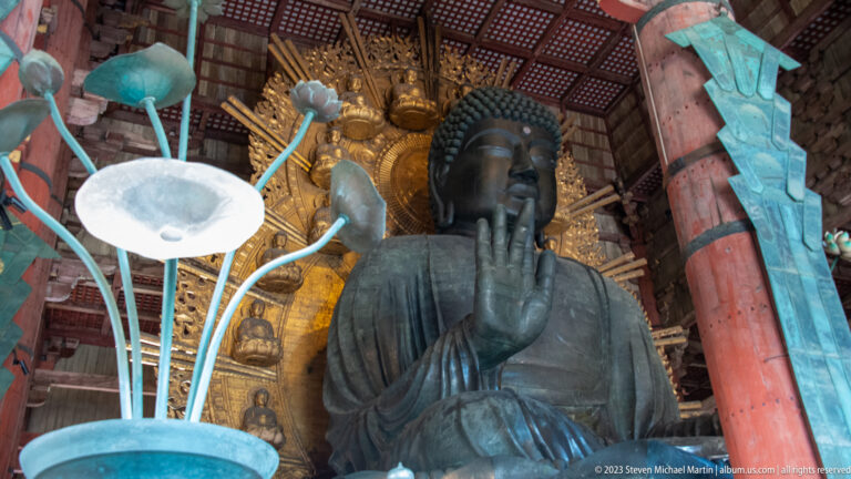 Lotus-form metal ritual lamp in front of Todai-ji’s seated bronze Daibutsu and gilded halo.