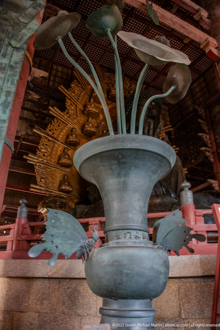 Large bronze ritual vessel holding stylized lotus stems, leaves, buds, and blossoms.