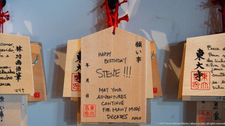Wooden ema plaque with an English birthday message for Steve hanging among other votive tablets.