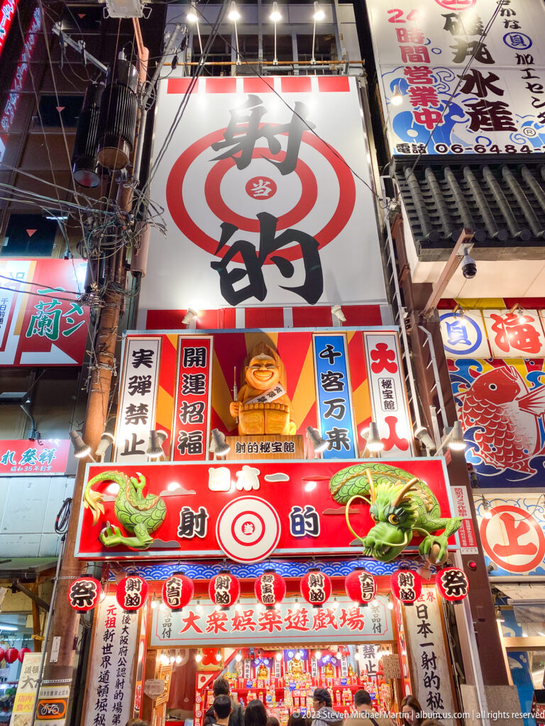 Bright Dotonbori restaurant façade covered with food sculptures, signs, and a target motif.
