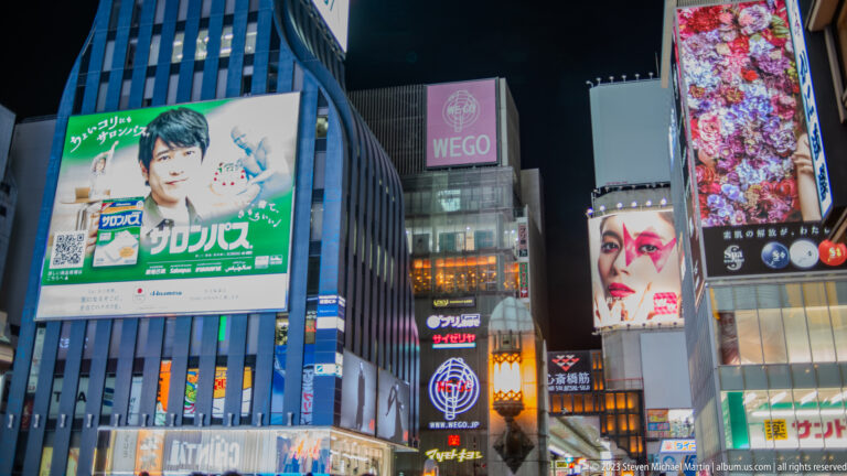 Close view of brightly lit product and fashion billboards in Dotonbori.