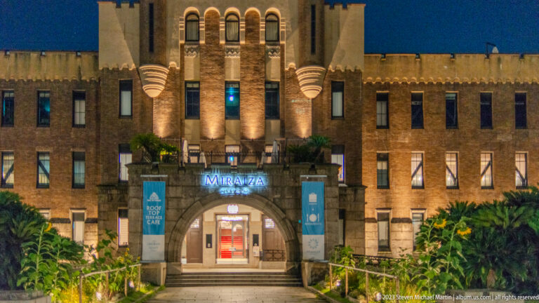 Illuminated brick façade and central entrance of Miraiza Osaka-Jo at night.
