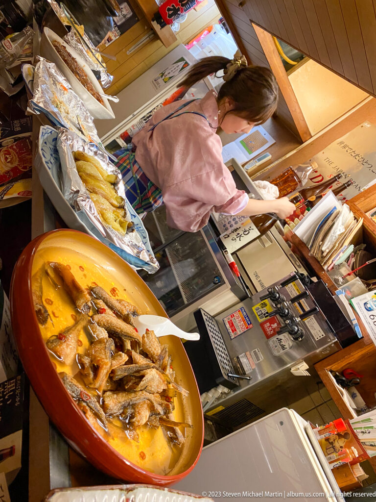 Server placing food on a crowded counter beside a large platter.