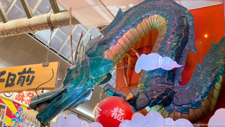 Large blue-green dragon sculpture coiling through an Osaka commercial interior.