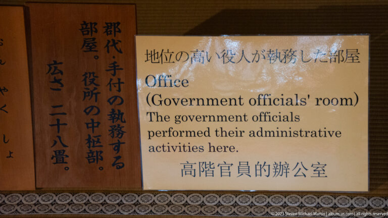 Bilingual museum sign identifies the room as an office where government officials carried out administrative duties.