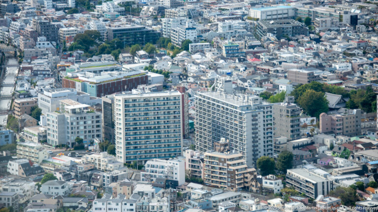 Mid-rise apartment blocks surrounded by tightly packed low-rise homes and narrow streets.