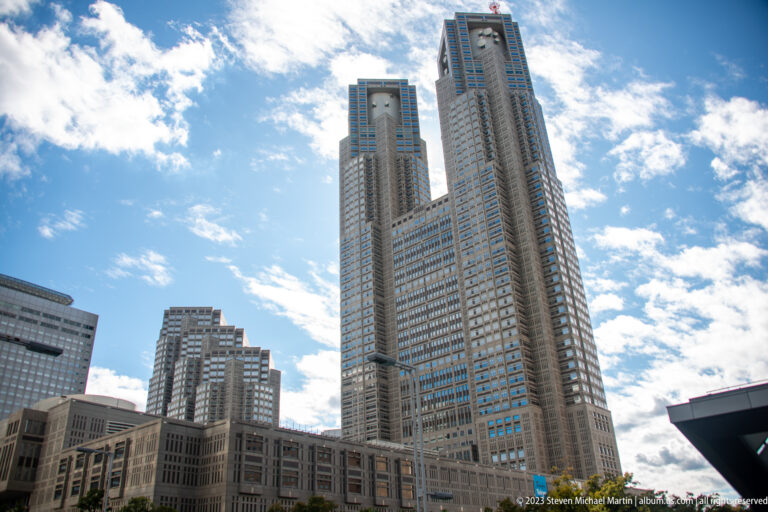 Close low-angle view of the Tokyo Metropolitan Government Building’s two towers and gridded façades.