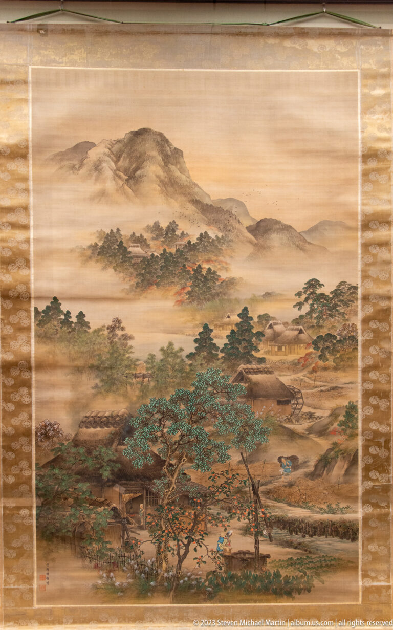 Detailed color landscape with mountains, mist, pine trees, villages, and winding roads.
