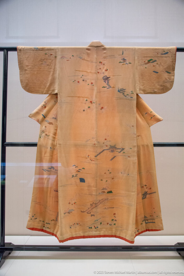 Light brown kimono with scattered birds, plants, and small landscape motifs.