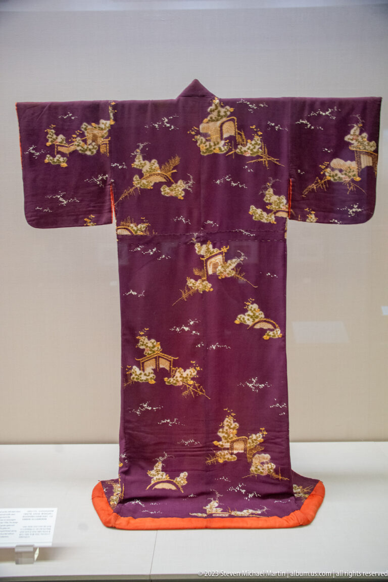 Deep purple kimono with repeated gold and multicolored narrative scenes.