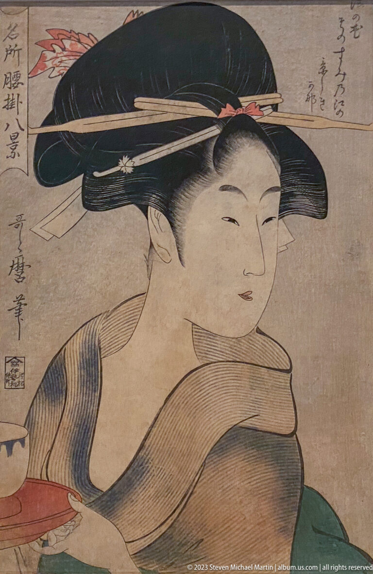 Ukiyo-e portrait of a woman with elaborate black coiffure, long hairpins, and patterned robe.