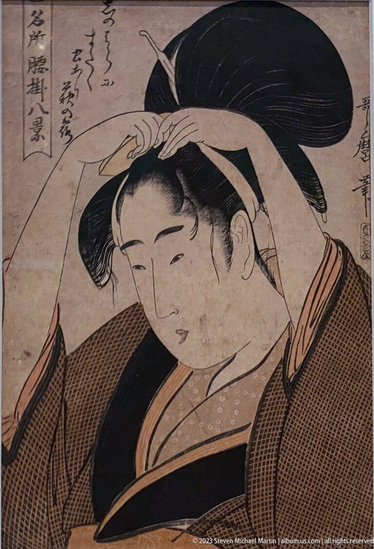 Ukiyo-e portrait of a woman adjusting her hair beneath a large black coiffure.