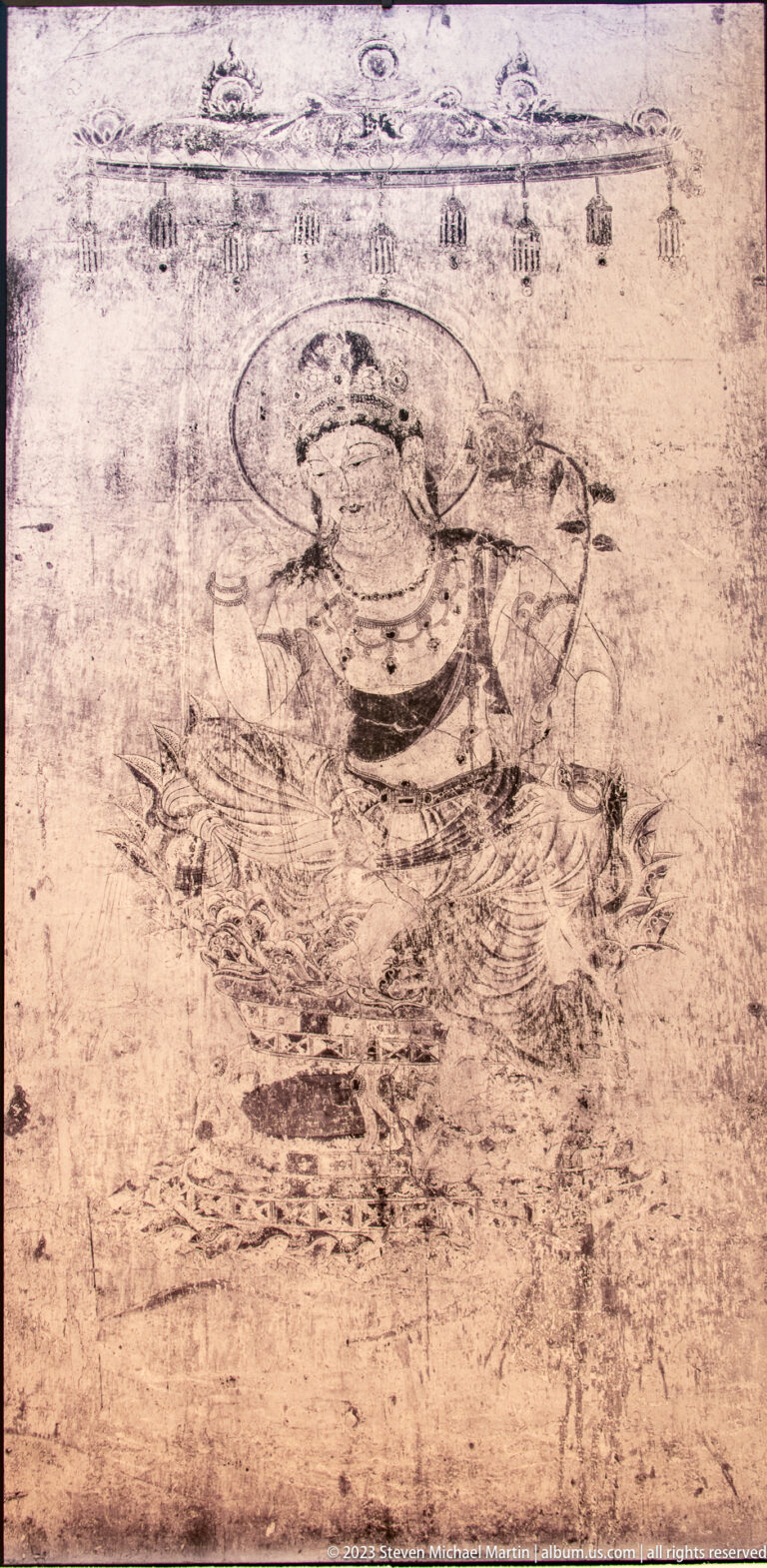Faint seated haloed Buddhist figure on a heavily worn mural surface.
