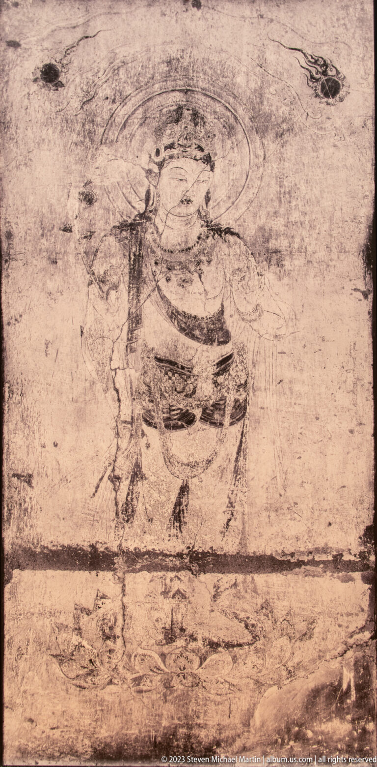 Faint standing haloed figure on a worn mural with extensive pigment loss.
