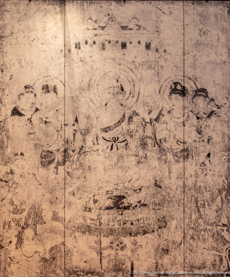 Faded Buddhist mural with a central haloed figure and several surrounding attendants.
