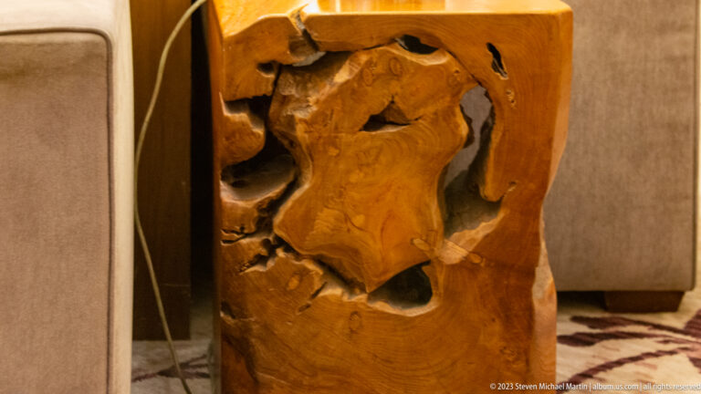Abstract carved wooden block with hollowed organic forms and visible grain.
