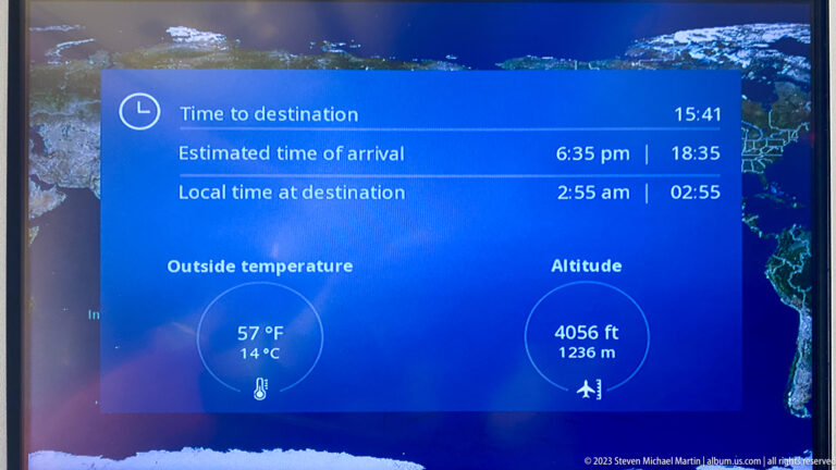 In-flight screen displaying arrival time, local time, outside temperature, and altitude.
