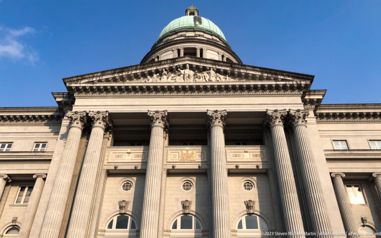Low-angle view of Corinthian columns, pediment, and green dome on the former Supreme Court.
