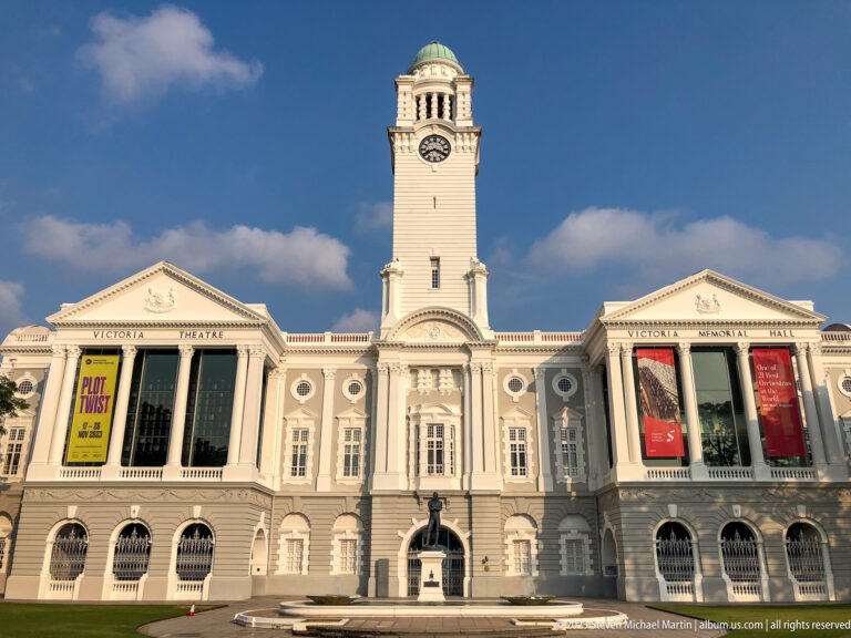Front view of Victoria Theatre and Concert Hall with central clock tower and banners.