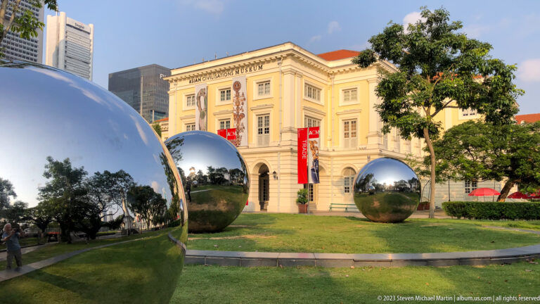 Mirror-like metal spheres on grass in front of the Asian Civilisations Museum.