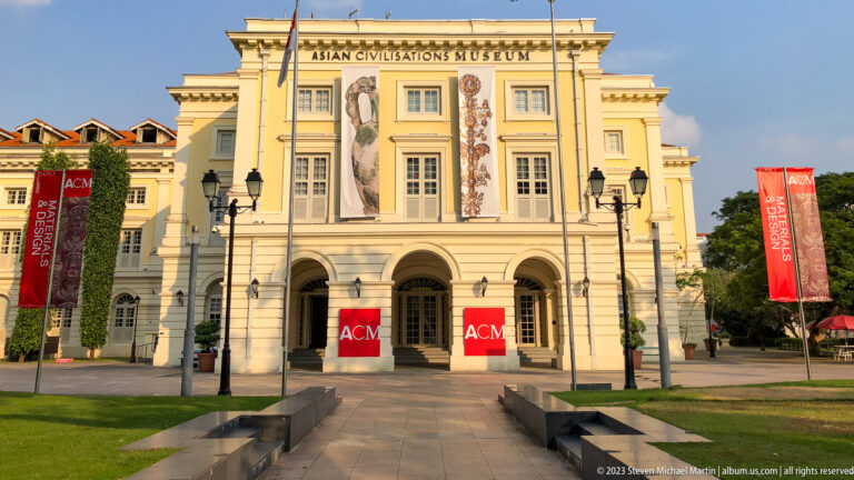 Frontal view of the Asian Civilisations Museum with lawns, banners, and arched entrances.
