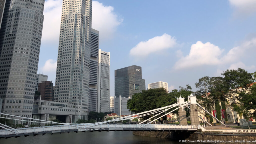 Cavenagh Bridge spanning the Singapore River with tall office towers beyond.