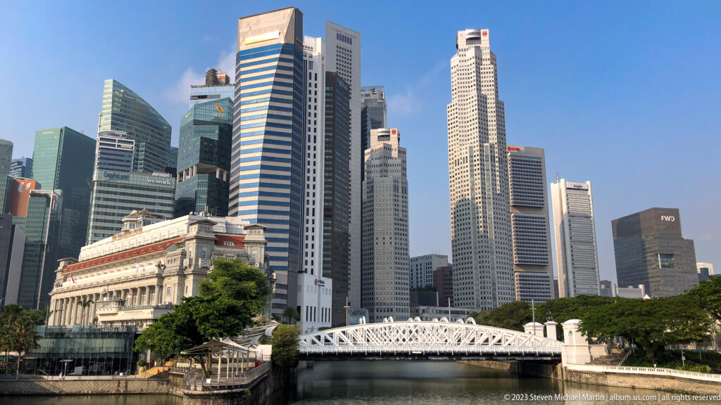 Singapore River panorama with Cavenagh Bridge, Fullerton Hotel, and skyscrapers.