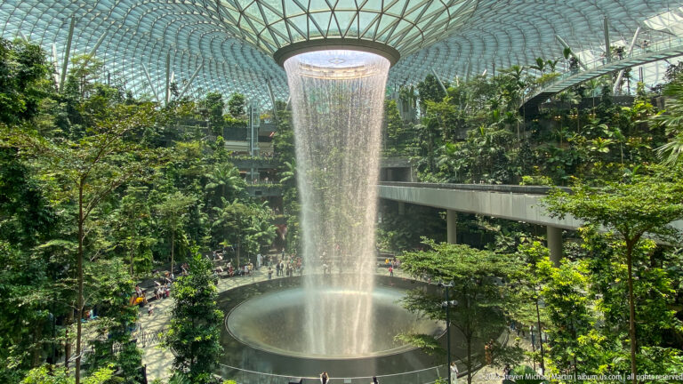 HSBC Rain Vortex falling into a circular basin inside Jewel Changi Airport.
