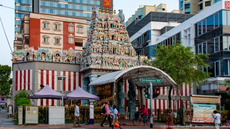 Street view of Sri Veeramakaliamman Temple’s sculpted gopuram amid modern buildings on Serangoon Road.